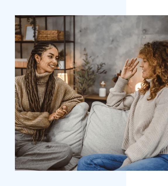 Group 3 Two women talking warmly on a couch, offering comfort and emotional support.