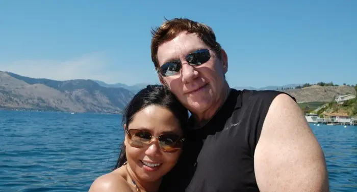 Bihn and Larry Binh and her late husband Larry embracing on a boat, smiling in the sun—cherished moment of love and togetherness.