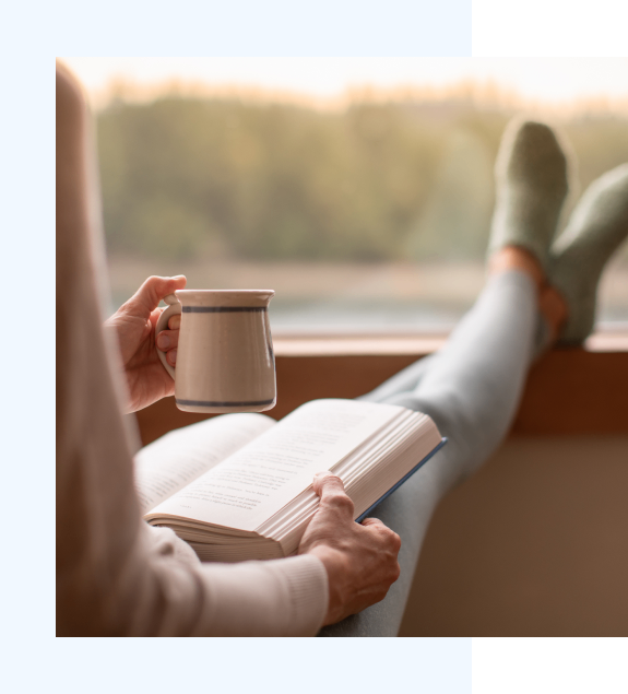 h2 5 Person reading a book with coffee in hand, feet up—evoking comfort, peace, and quiet resilience.