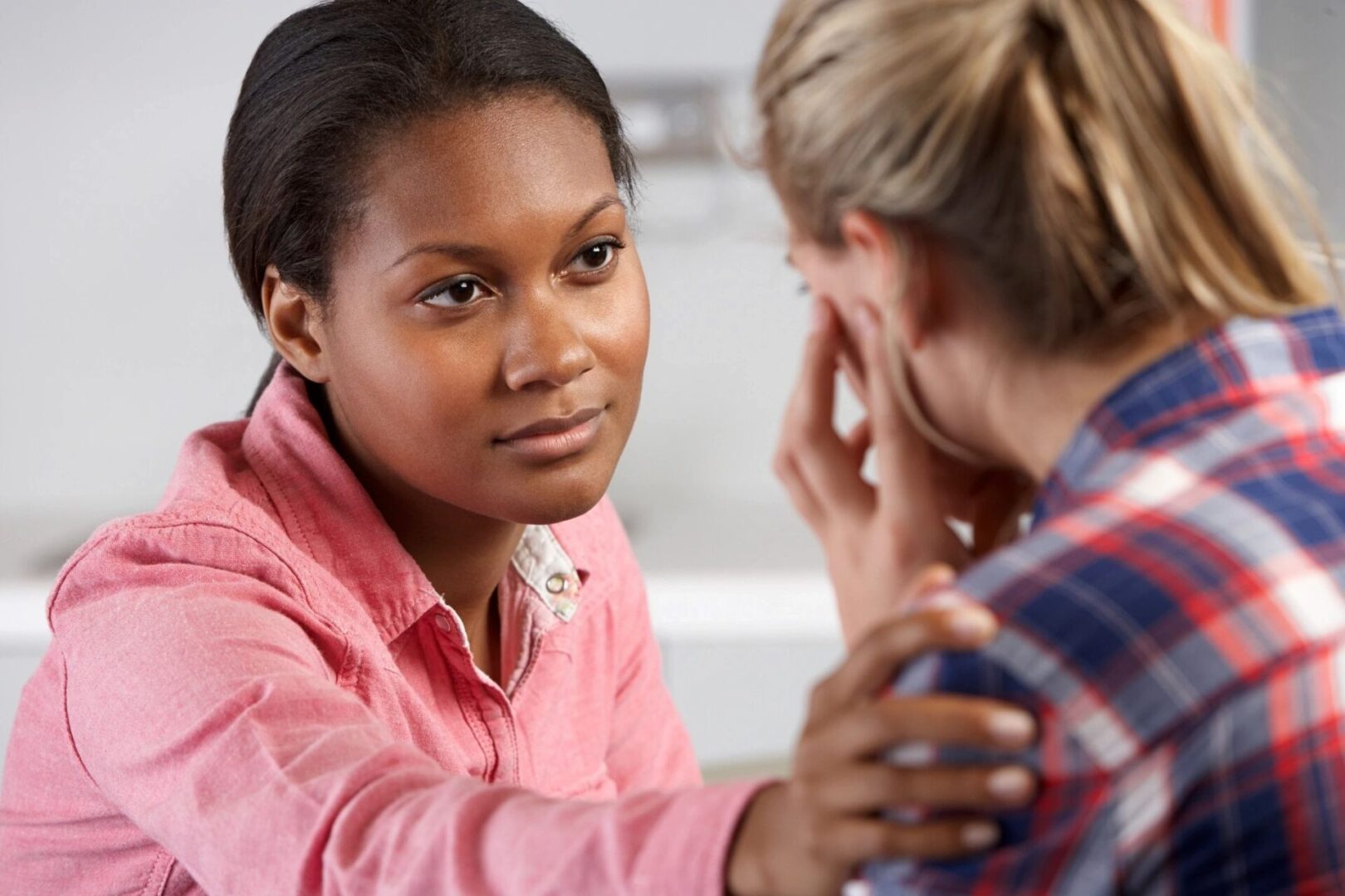 Woman offering comfort and emotional support to a friend during a moment of grief.